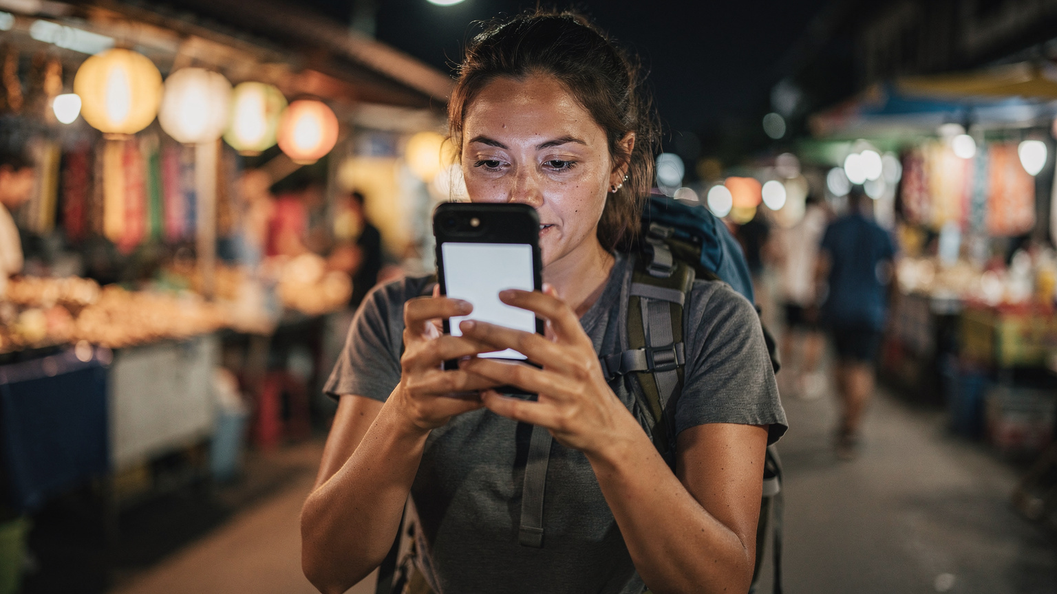 一位旅行者在泰国街头,通过手机设置页面查看已安装的 eSIM 配置文件,背景是当地的特色小吃摊和人来人往的街道。