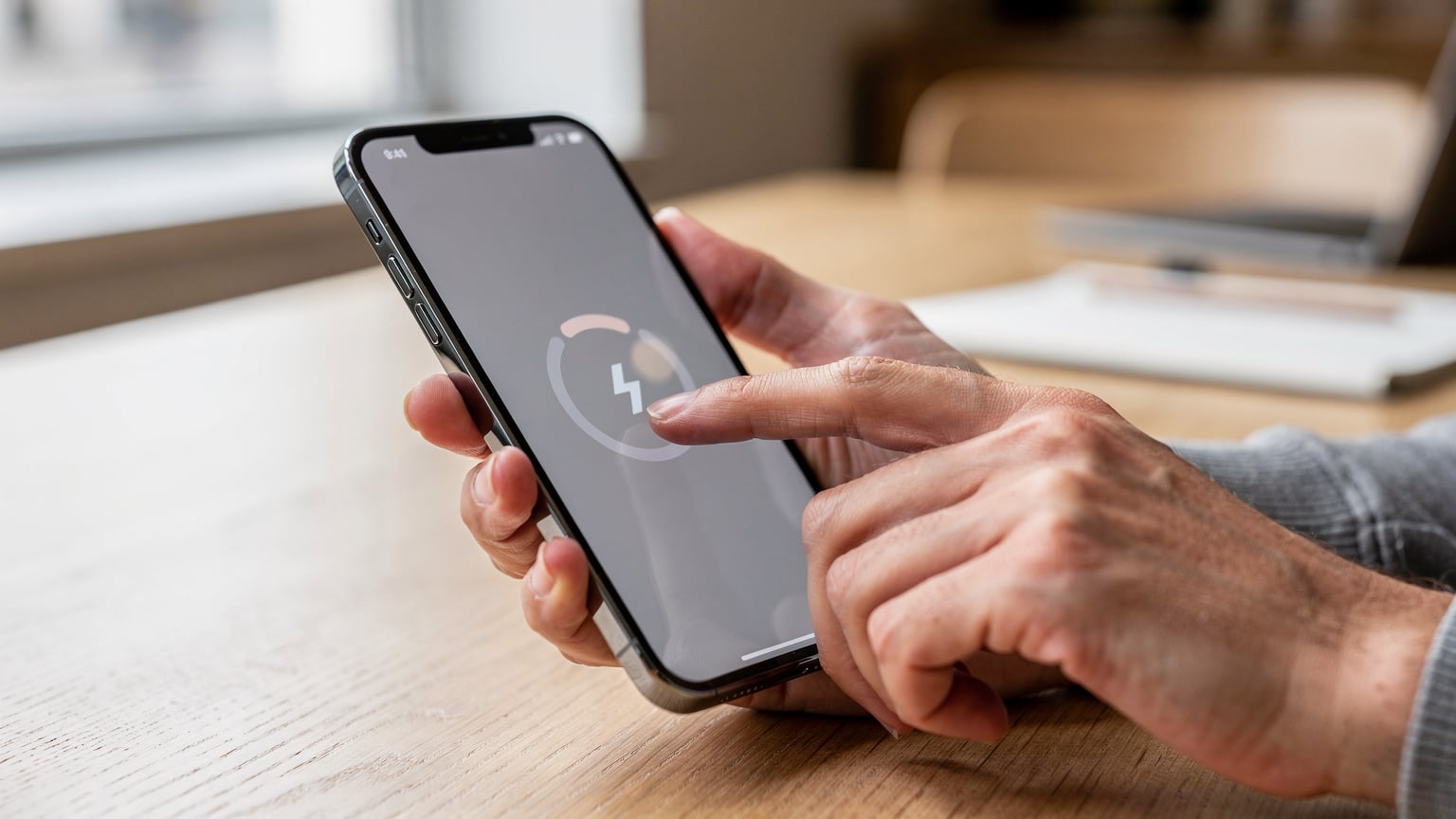 Human hands interacting with a smartphone screen to activate an eSIM profile.