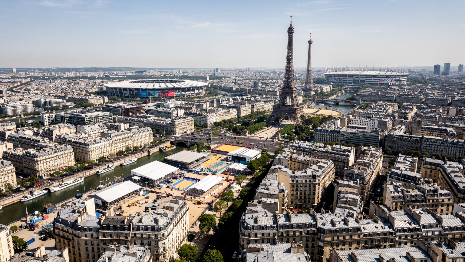 Una veduta aerea di Parigi con gli stadi olimpici e le infrastrutture temporanee, mostrando la densità della città durante un grande evento.
