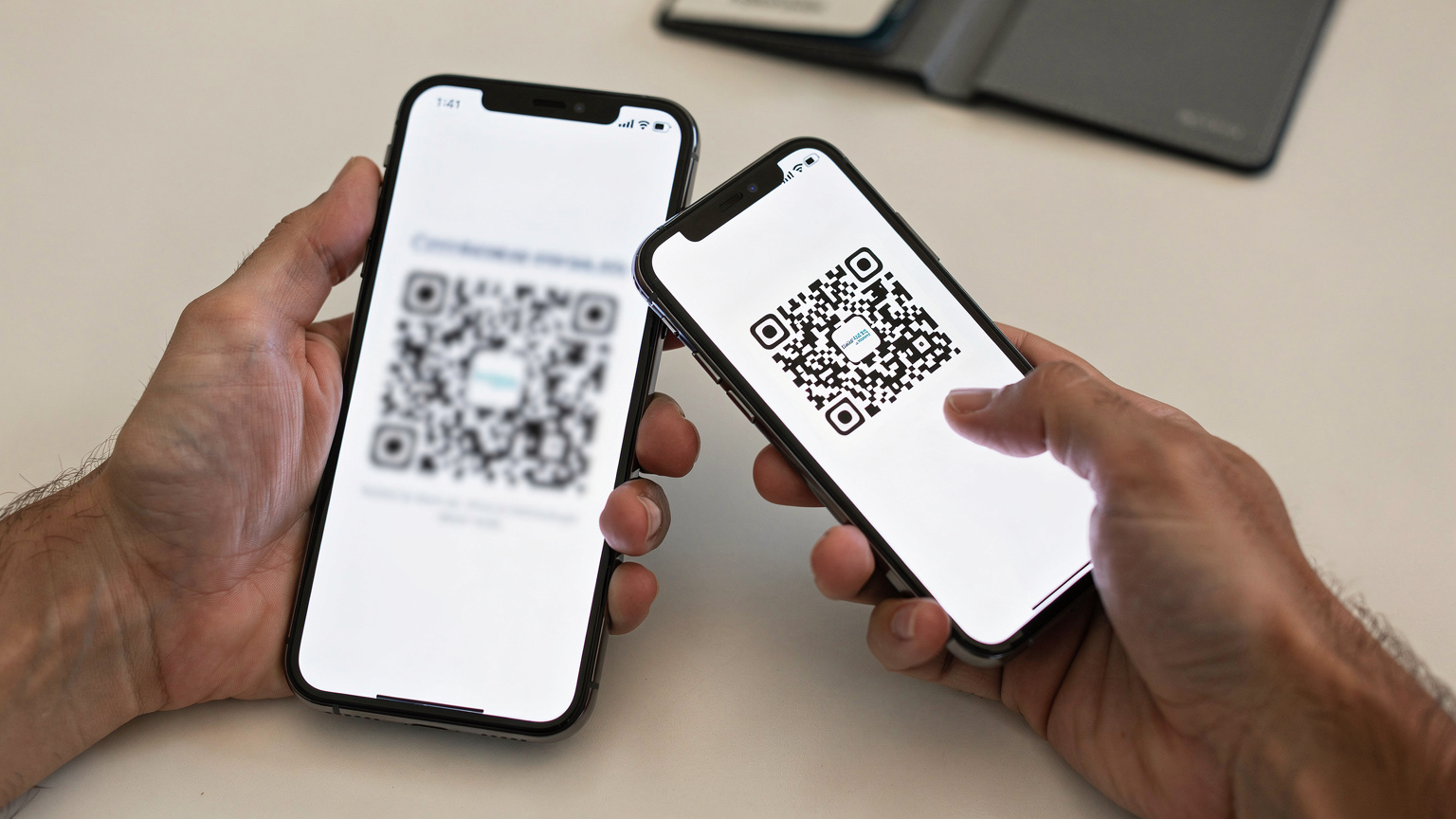 Nahaufnahme von Händen, die ein Smartphone halten und einen QR-Code für die eSIM-Installation scannen, mit einer Reisepasshülle im Hintergrund.