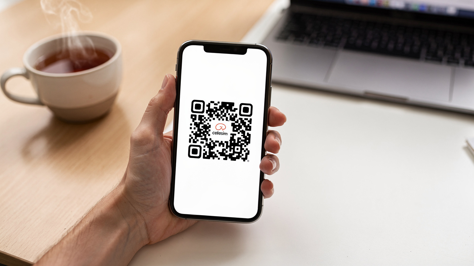 一隻手輕輕拿起一部智能手機,屏幕上清晰顯示Cellesim eSIM的激活QR Code,背景是充滿現代感的辦公桌,旁邊放著一杯冒著熱氣的茶,暗示著便捷的線上激活體驗。