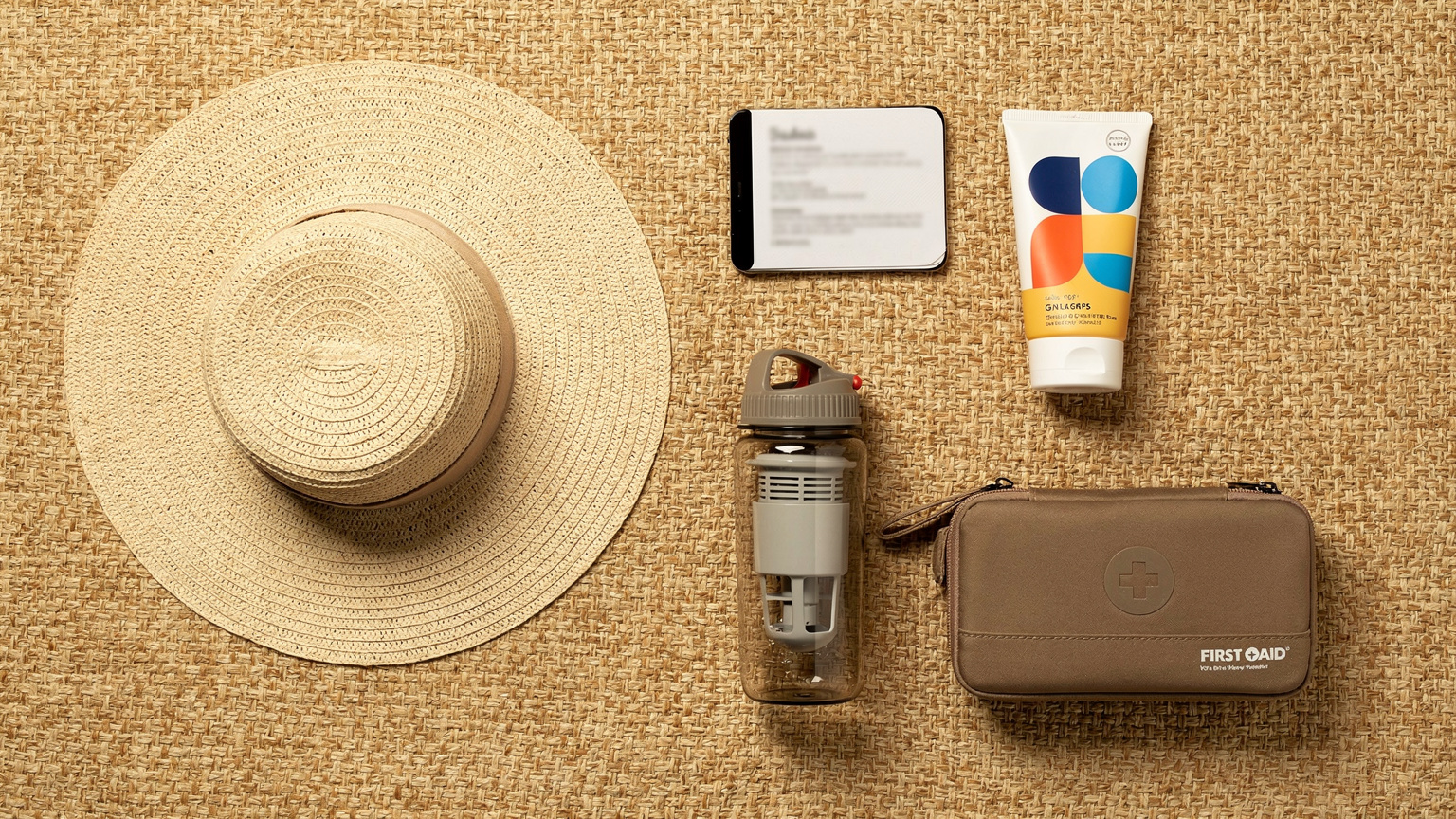 An overhead flat-lay shot of essential travel items for Sudan: a passport, a Cellesim-enabled smartphone, a wide-brimmed hat, sunscreen, a water filter bottle, and a small first-aid kit, all neatly arranged on a sandy-colored fabric.
