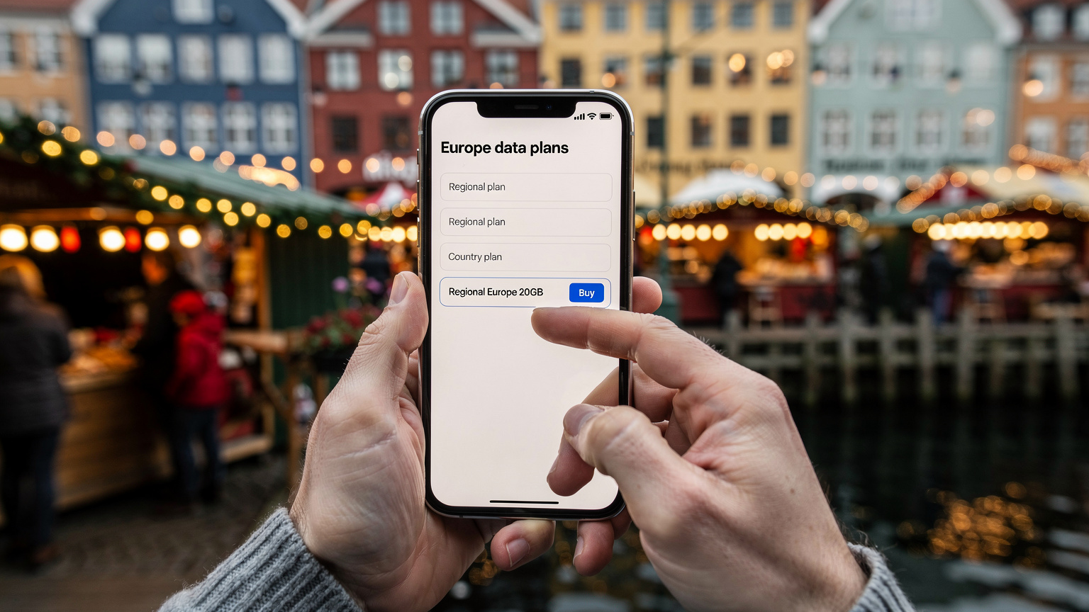 En oversikt over flere eSIM-pakker på en smarttelefonskjerm, holdt av hender som velger en plan. I bakgrunnen ser man et travelt julemarked i København, Nyhavn.