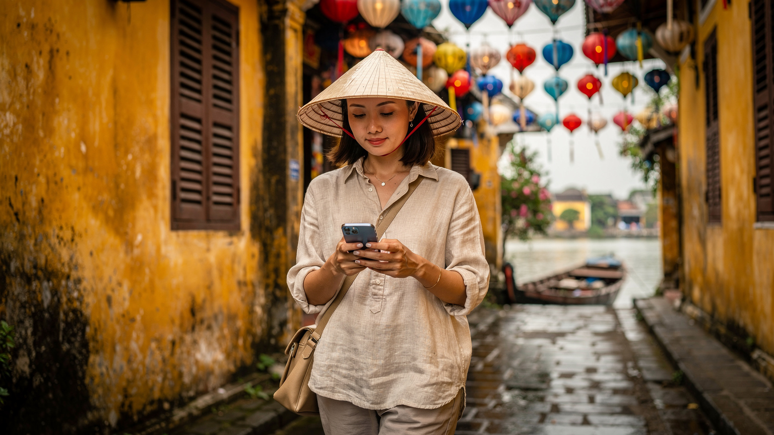 Một du khách đang sử dụng iPhone để điều hướng trong khu phố cổ Hội An, kiểm tra lại cài đặt eSIM sau khi chuyển đổi thiết bị.