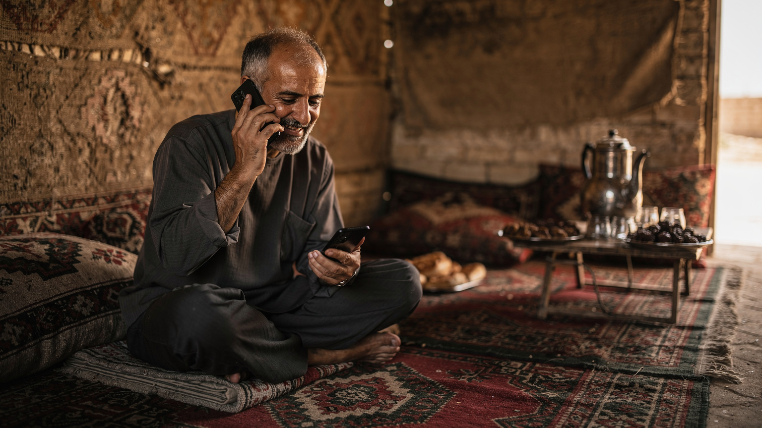 یک زائر در حال استراحت در یک موکب ساده در مسیر نجف به کربلا، در حالی که با گوشی خود در حال برقراری تماس تصویری با خانواده است.