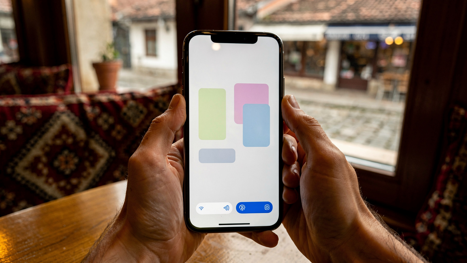 Bir kafenin penceresinden görünen Saraybosna sokaklarında, elinde telefon tutan bir kişinin yakından çekimi, ekranında Cellesim uygulamasının aktivasyon adımları görülüyor.