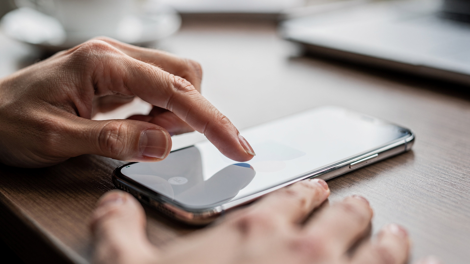 Een persoon steekt een vinger uit naar een smartphone, waarbij een eSIM-profiel wordt geactiveerd op een overzichtelijke en moderne interface, met de nadruk op de hands-on interactie.