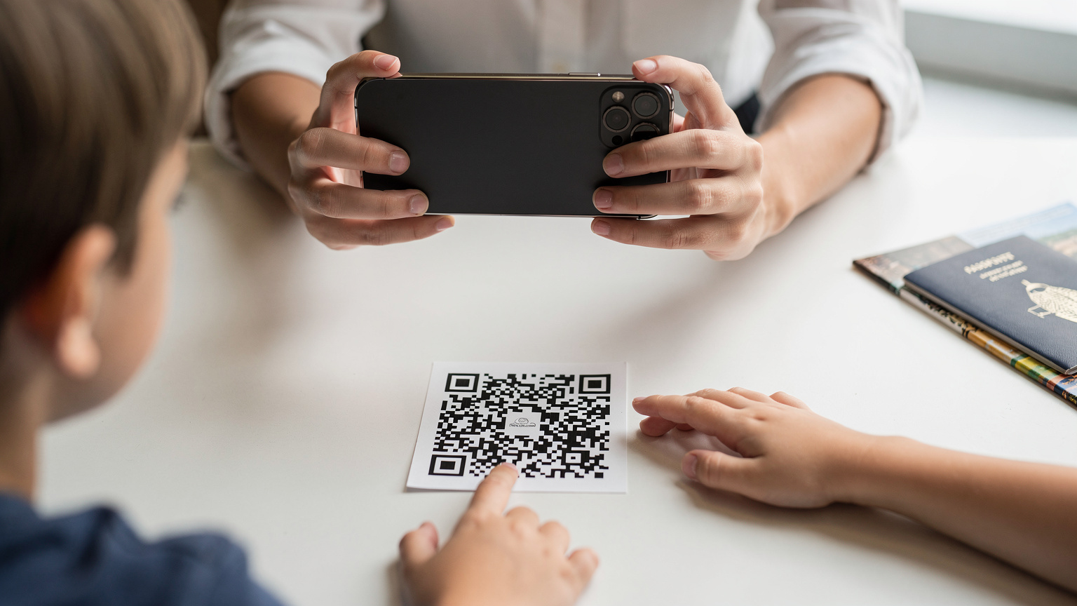 Uma mulher a digitalizar um código QR com um iPhone 18 para ativar um eSIM, com mãos de crianças a aparecerem no enquadramento.