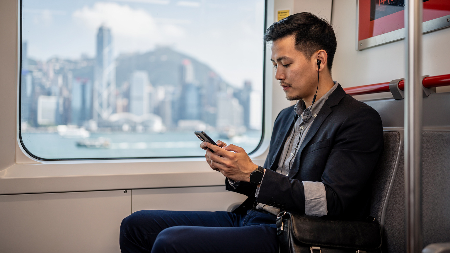 一位通勤者在香港地铁车厢内查看手机上的eSIM年卡套餐详情,窗外是维多利亚港的繁忙景象。