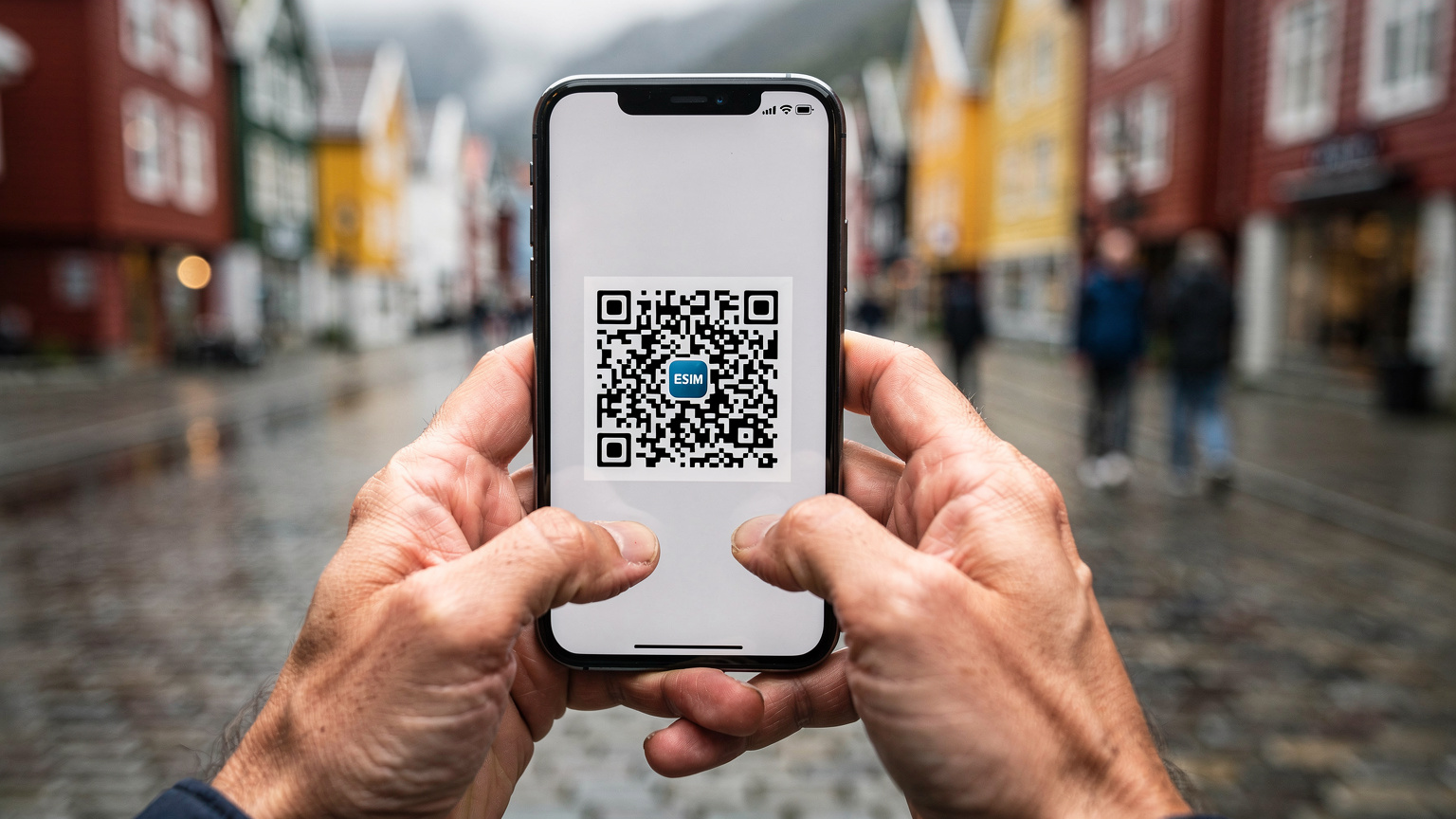 Nærbilde av hender som holder en smarttelefon med en QR-kode på skjermen, klar for eSIM-aktivering, med et uklart bakteppe av en travel gate i Bergen.