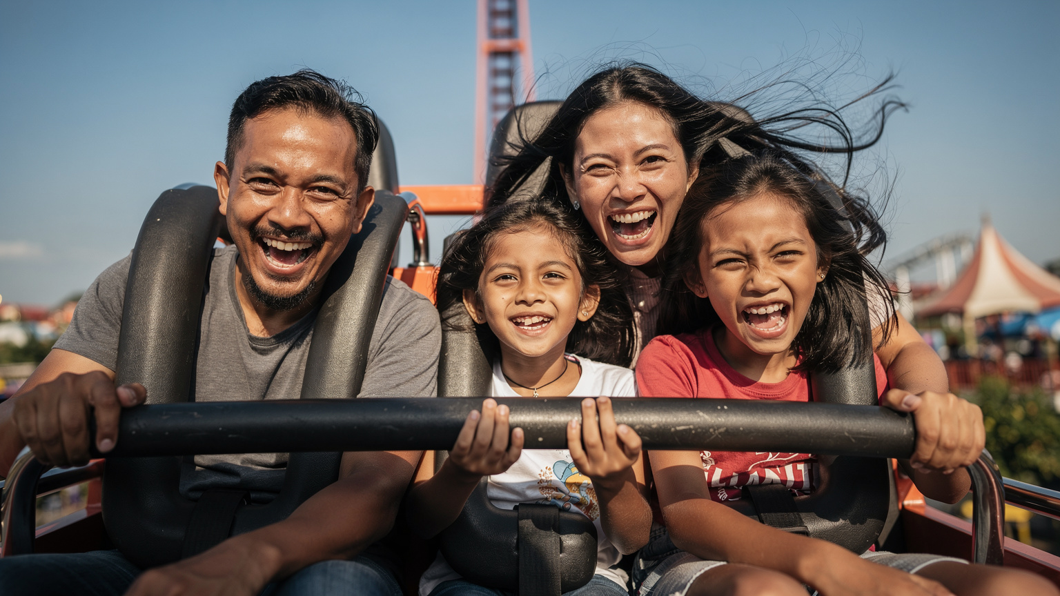 Seorang keluarga Indonesia yang terdiri dari ayah, ibu, dan dua anak, sedang tertawa bahagia saat menaiki wahana roller coaster di Dunia Fantasi Ancol, Jakarta. Langit cerah dengan sedikit awan.