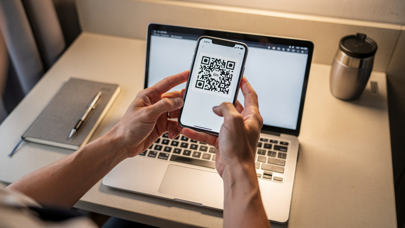 Eine Person hält ein Smartphone und scannt einen QR-Code auf einem Laptop, um eine eSIM zu aktivieren, im Stil einer Schritt-für-Schritt-Anleitung.