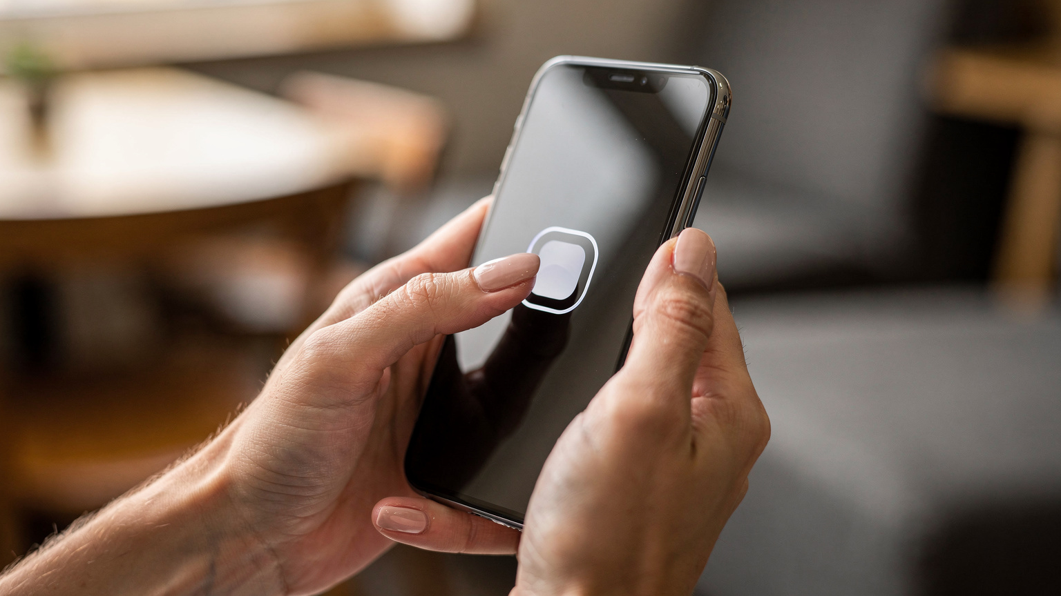 Close-up of a person's hands gently holding a smartphone, with their index finger tapping an 'Activate eSIM' button on the screen.