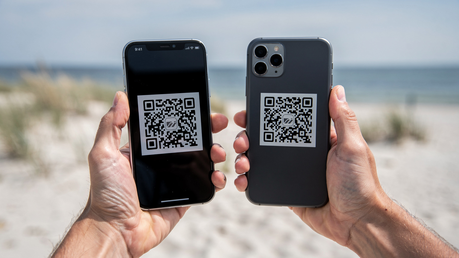 Rodzic skanujący kod QR Cellesim z ekranu drugiego smartfona na swoim telefonie, w tle rozmyty widok na piaszczystą plażę z wydmami i morzem.