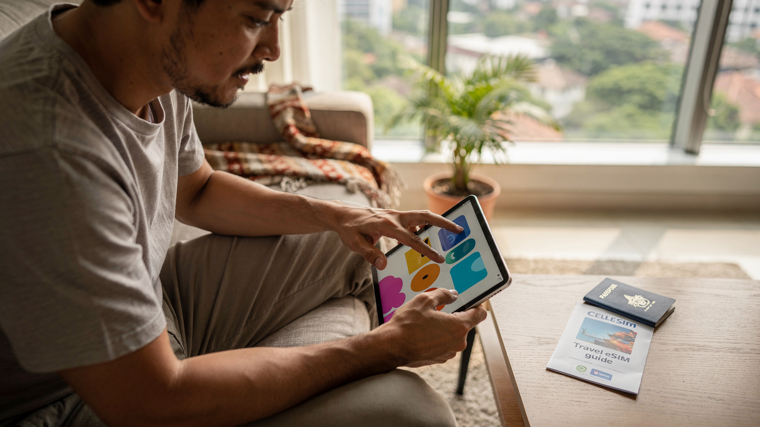 Seorang ayah di Jakarta sedang mengunduh episode kartun Disney+ ke iPad anaknya, memastikan semua sudah siap sebelum penerbangan panjang.