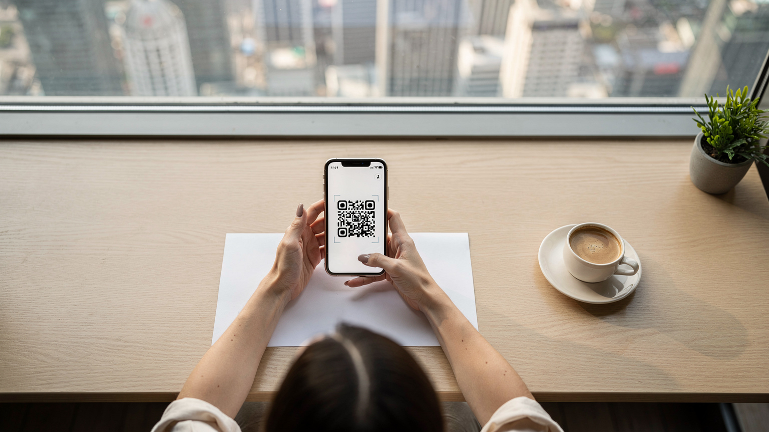 Một du khách đang cầm điện thoại và quét mã QR để cài đặt eSIM tại một quán cà phê yên tĩnh ở Thượng Hải, Trung Quốc, với phong cảnh thành phố hiện đại phía sau cửa sổ.