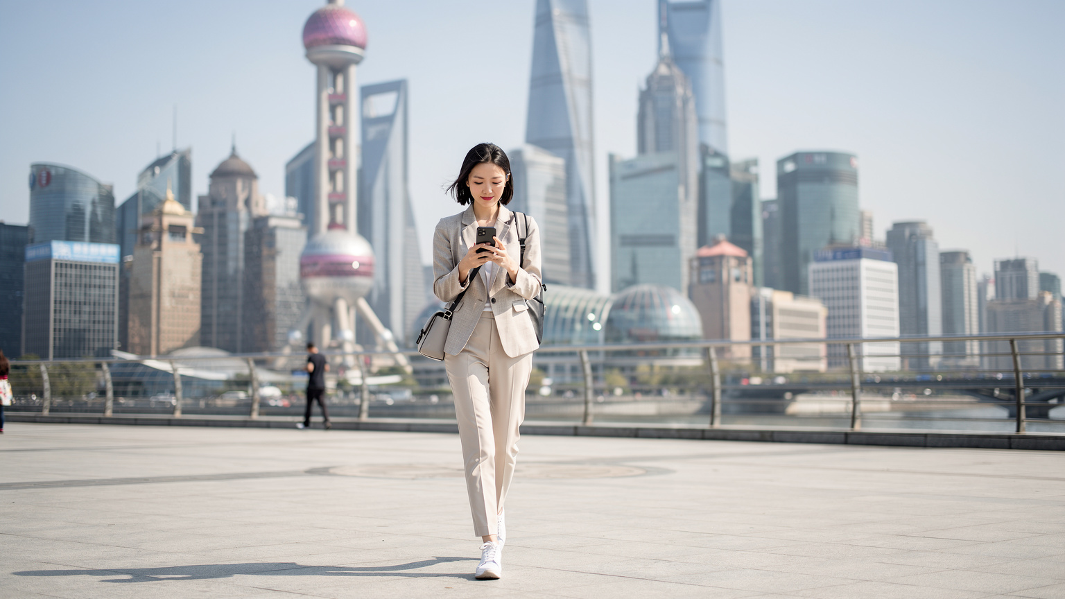 A traveler in Shanghai uses their phone freely, connected with an eSIM, in front of the iconic Oriental Pearl TV Tower.