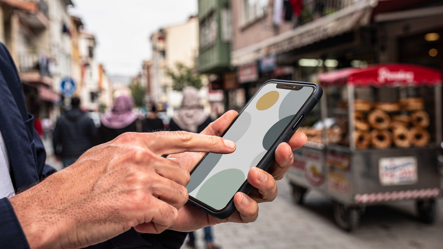 Nahaufnahme von Händen, die ein Smartphone halten, auf dem eine Cellesim-App geöffnet ist, mit dem Hintergrund einer belebten türkischen Straße, die die einfache Datenverwaltung unterwegs darstellt.
