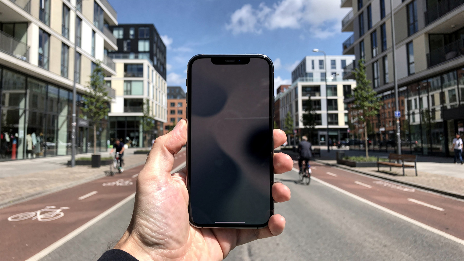 En hånd holder en smartphone, der viser en eSIM-aktiveringsskærm, med en baggrund af en travl, moderne dansk bydel, der symboliserer fremtidens forbundne liv.