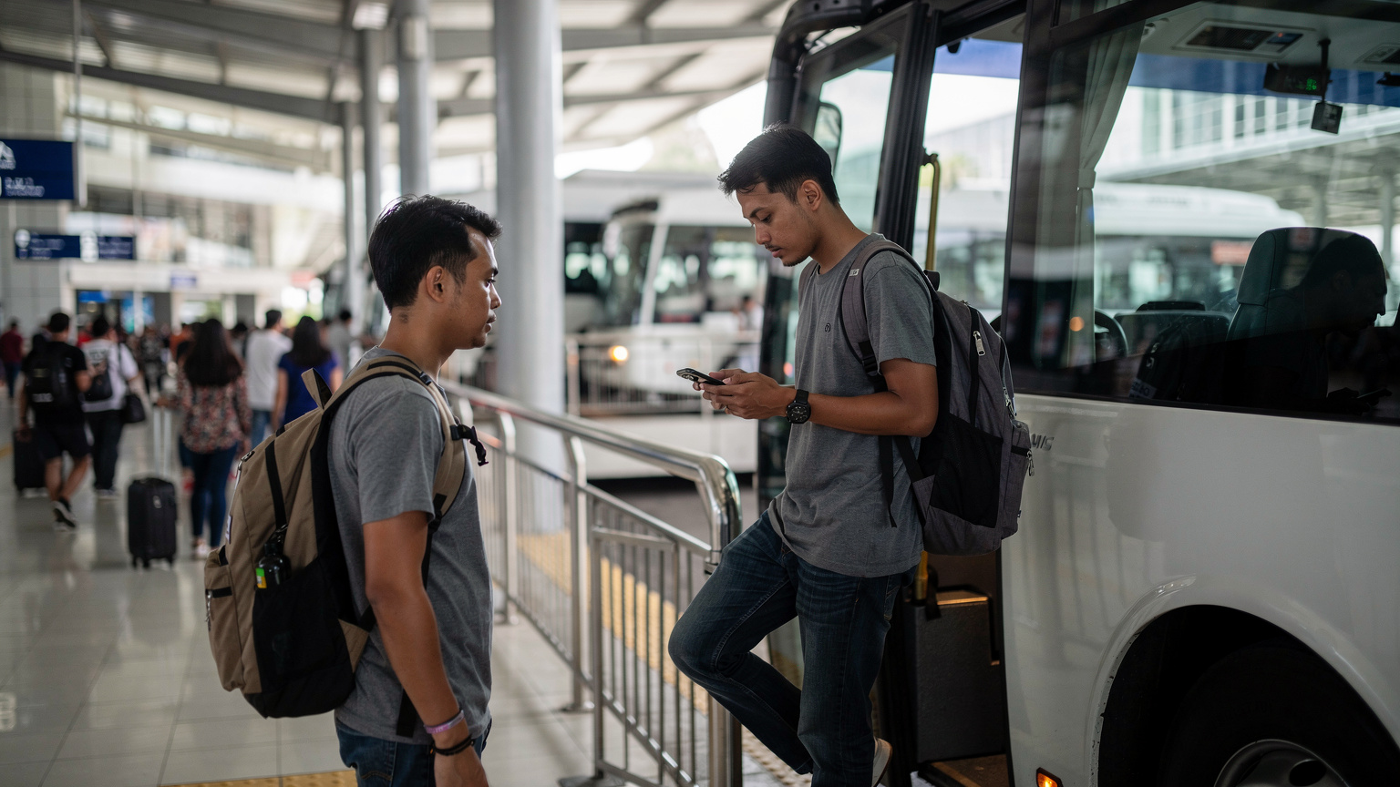 Seorang pengembara sedang menaiki bas di Terminal Bas Bersepadu Selatan (TBS), Kuala Lumpur, dengan beg sandang dan telefon di tangan, bersedia untuk perjalanan.