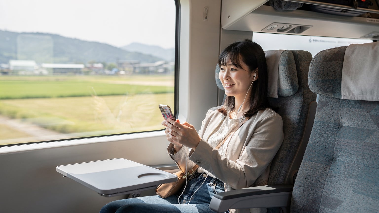 韓国の高速鉄道KTX車内で、eSIMを使って動画を快適に視聴する旅行者。