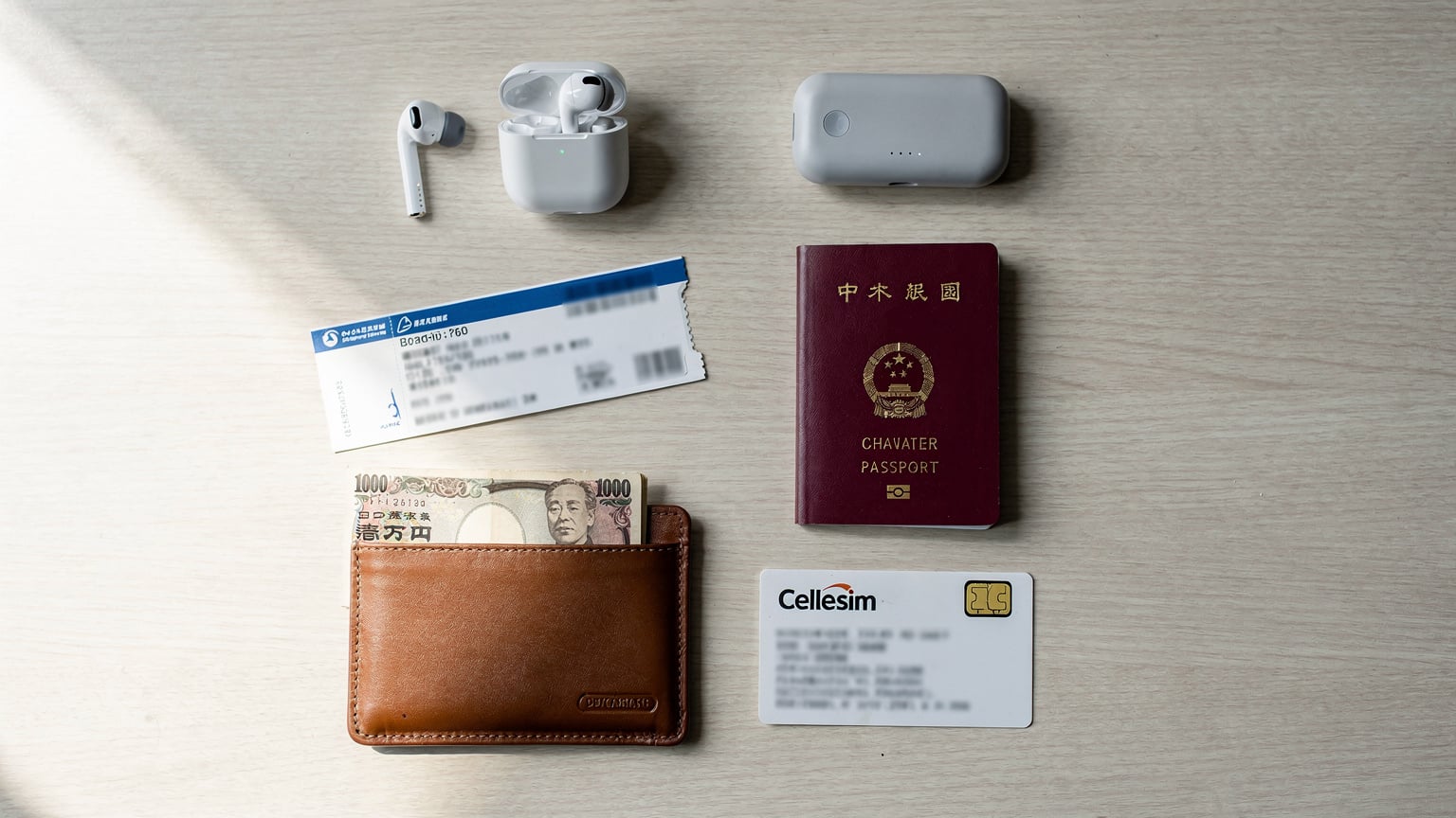 一张旅行者护照、登机牌、充电宝和Cellesim eSIM卡说明书的平铺图,旁边放着一个装着当地货币的钱包。