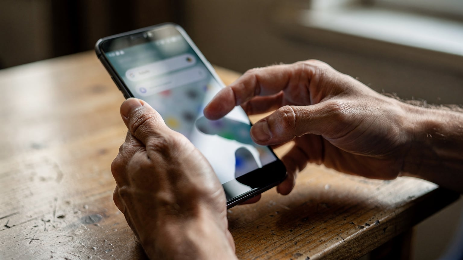Close-up of a traveler's hands, with a slight tan, gently tapping through the settings menu on an Android phone, looking for network details.