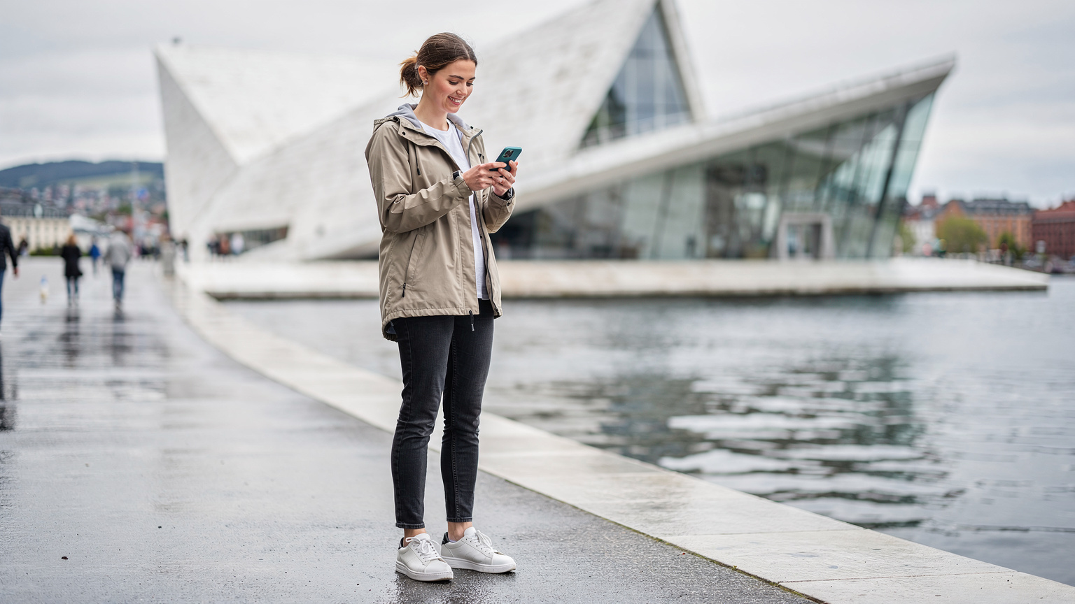 En kvinne bruker sin smarttelefon for å navigere i Oslos sentrum, med den ikoniske Operaen i bakgrunnen.