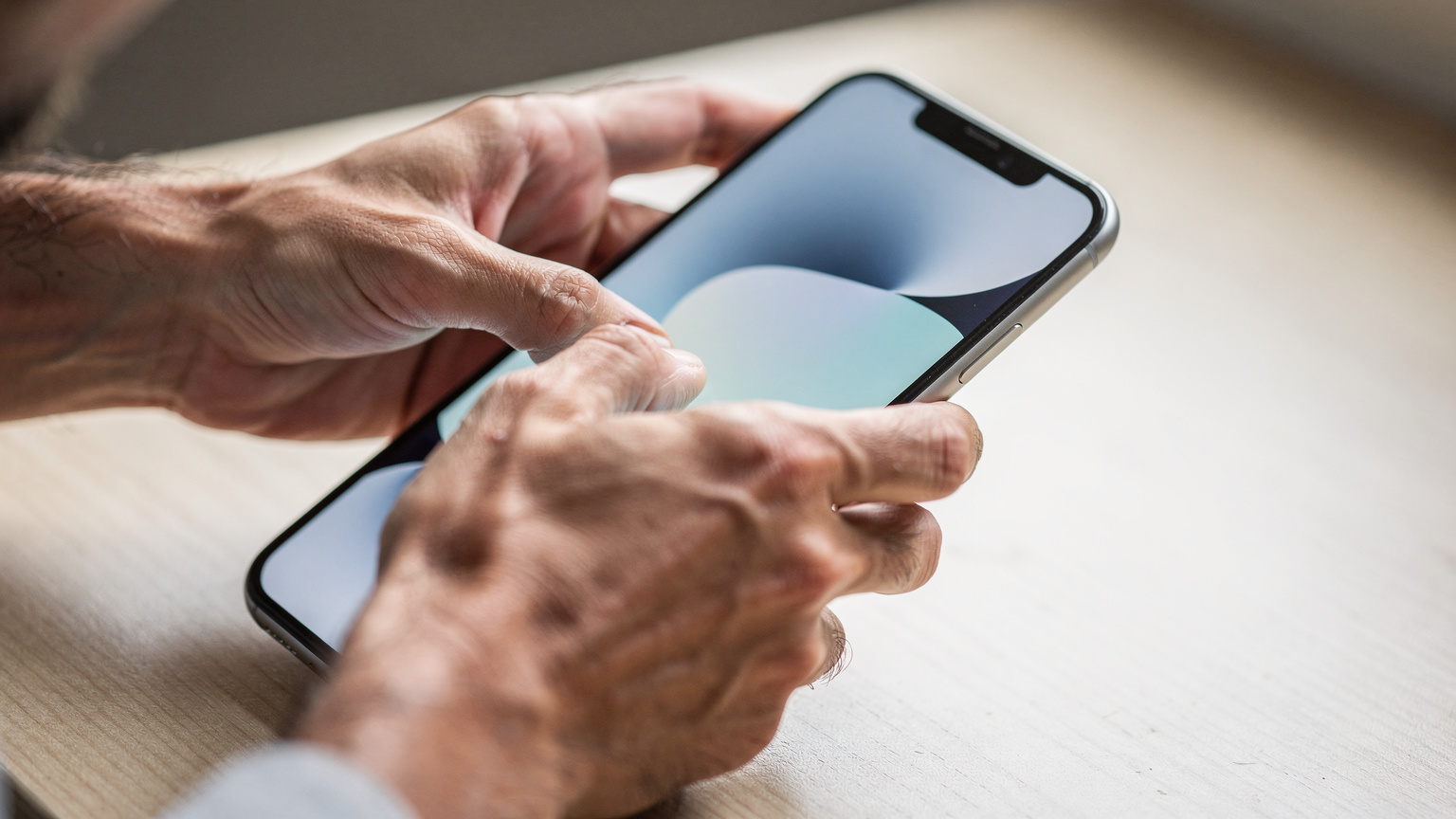 A close-up of a person's hands delicately interacting with a smartphone screen, possibly adjusting settings or confirming an eSIM activation. The focus is on the human-device interface, with soft, natural light.