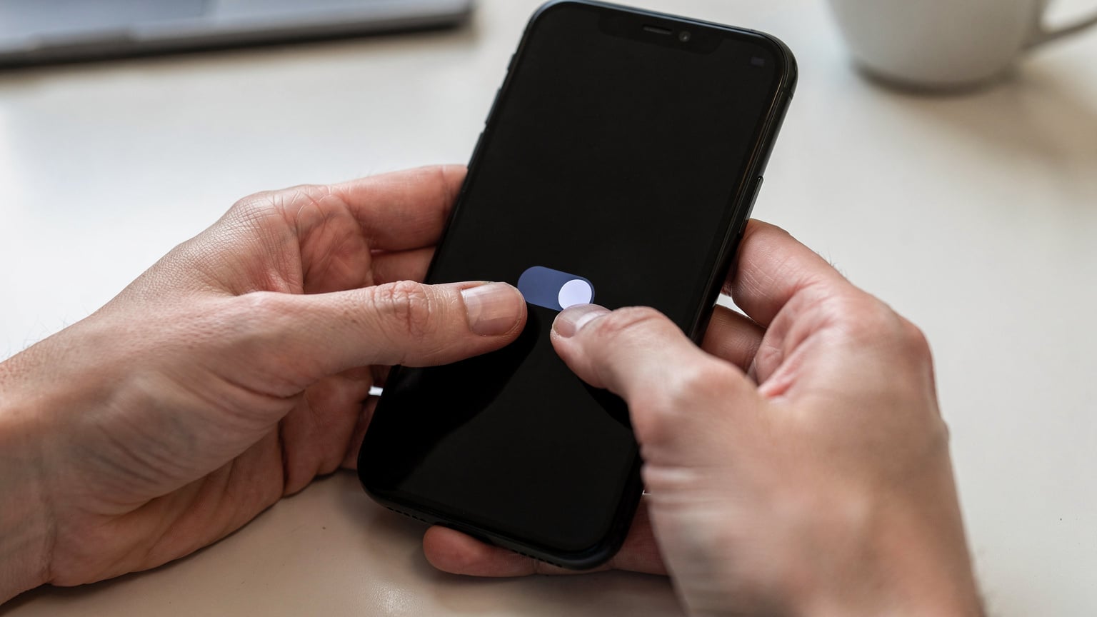 スマートフォンの設定画面で、データローミングのオン/オフを慎重に確認している手のクローズアップ。誤った設定による高額請求を防ぐための重要な操作。