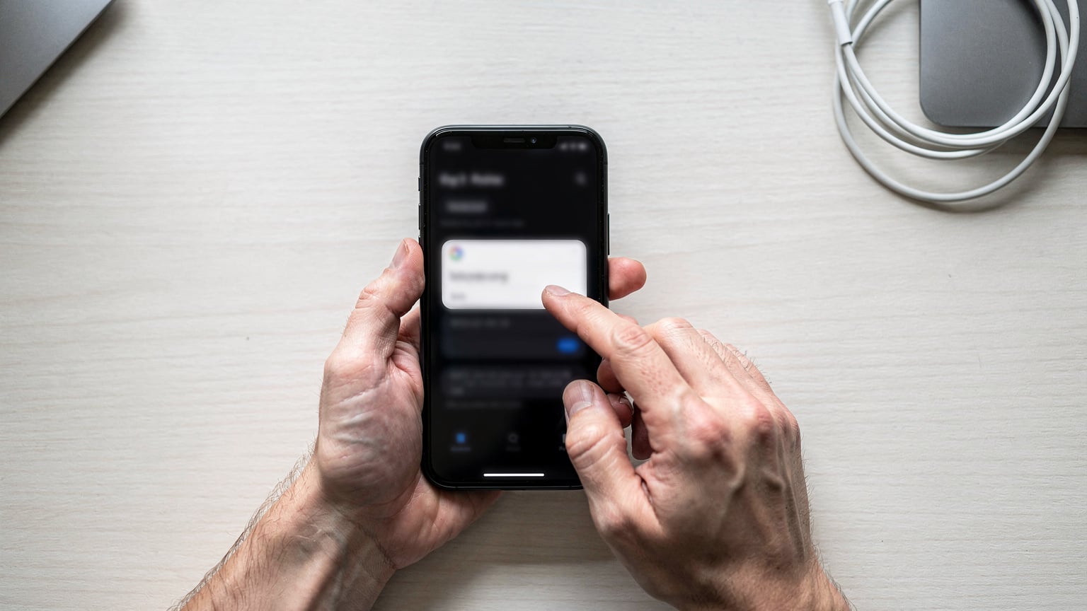 Närbild av händer som håller en smartphone och navigerar genom inställningsmenyn för att kontrollera APN-inställningar, med en minimalistisk, teknisk känsla.