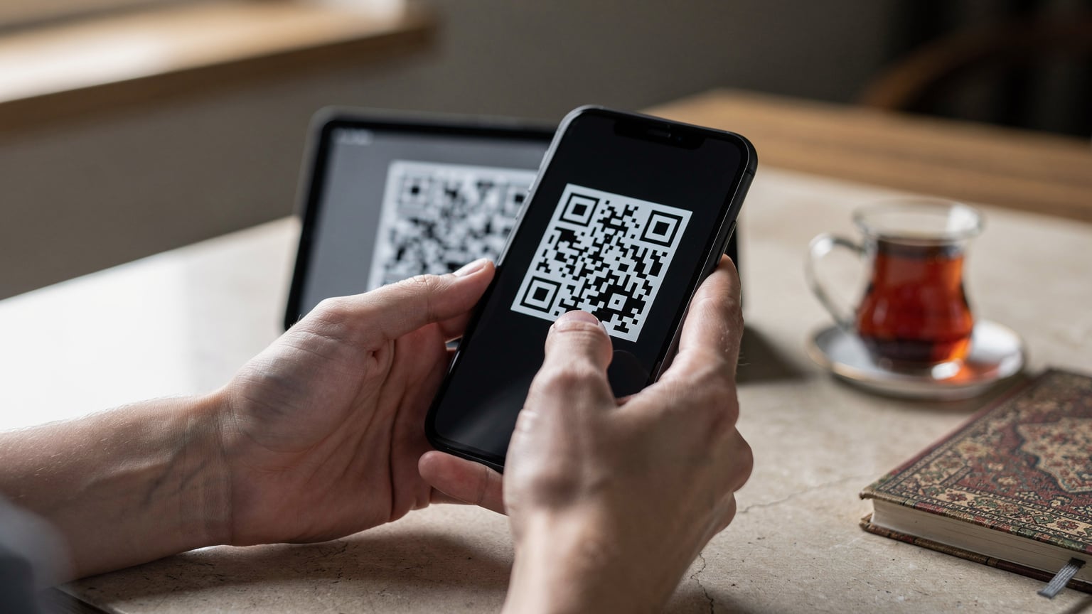 Nahaufnahme von Händen, die ein Smartphone halten, während der QR-Code einer eSIM gescannt wird.