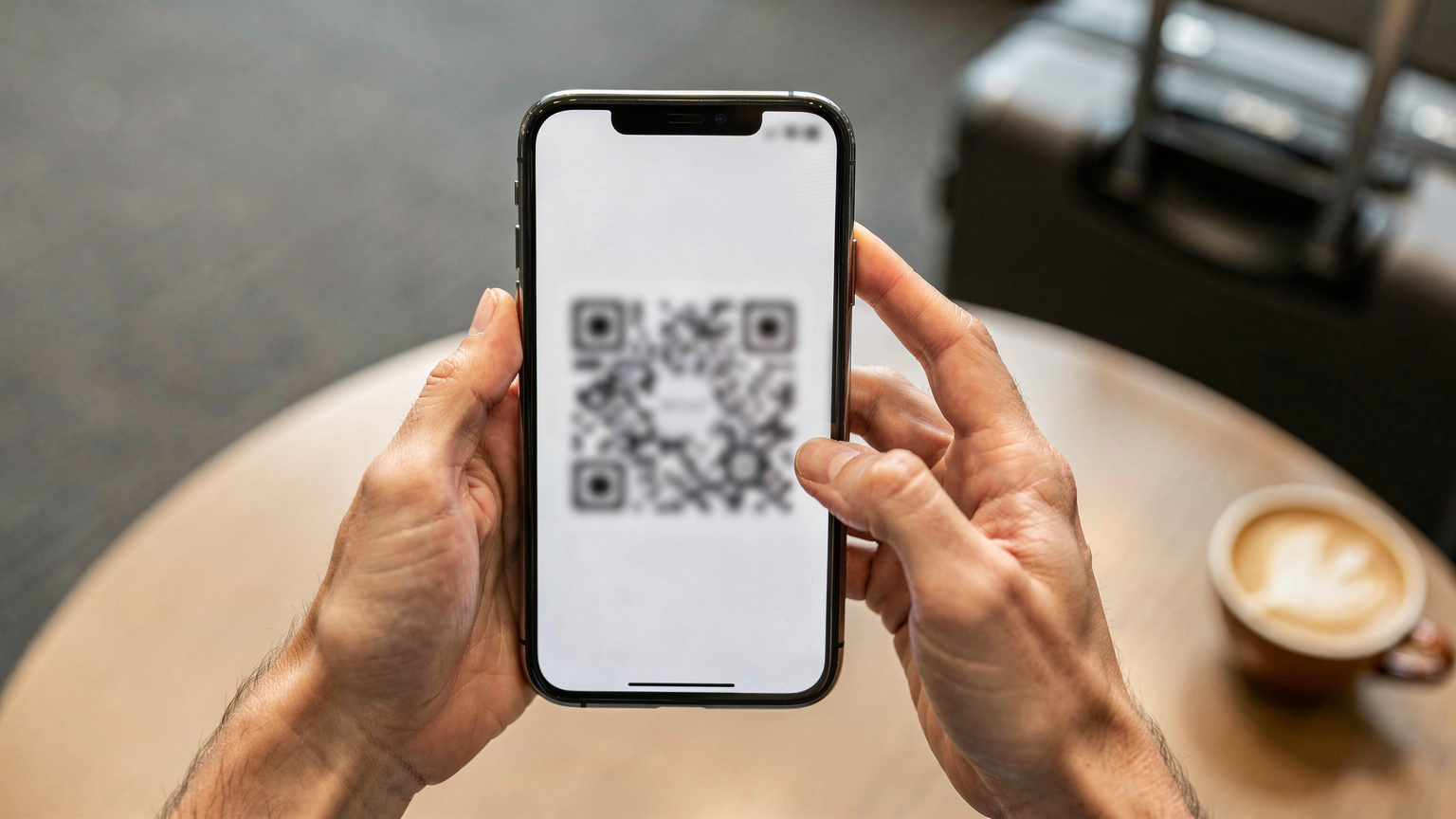 Bir kadının elleri, bir akıllı telefonun ekranında eSIM QR kodunu tararken yakın çekim.