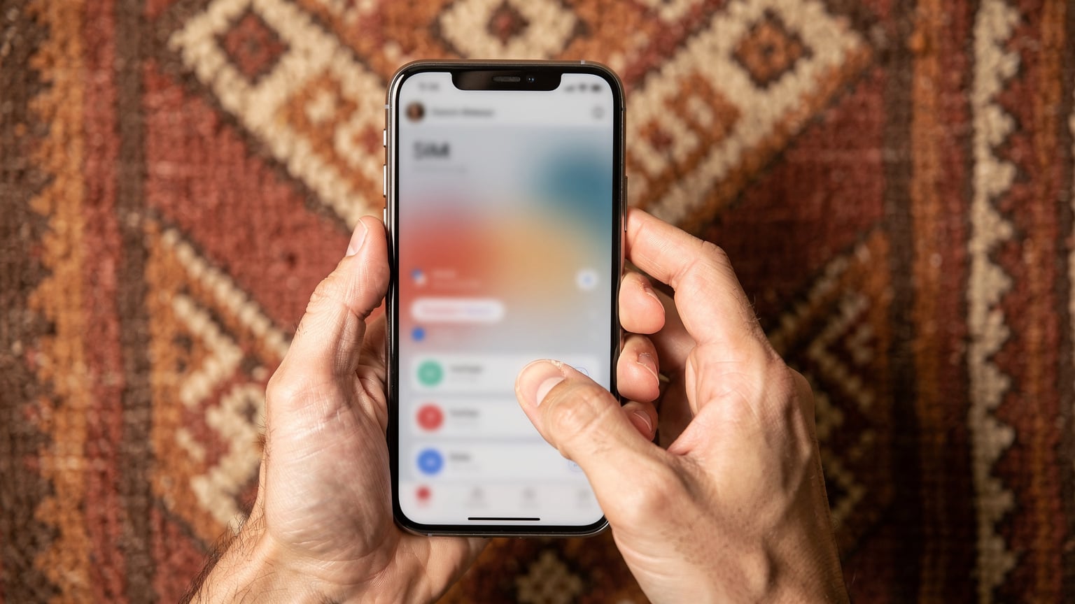 Ręce podróżnika trzymającego smartfon z aktywną aplikacją eSIM i widocznymi opcjami pakietów danych, na tle tradycyjnego marokańskiego wzoru tekstylnego.