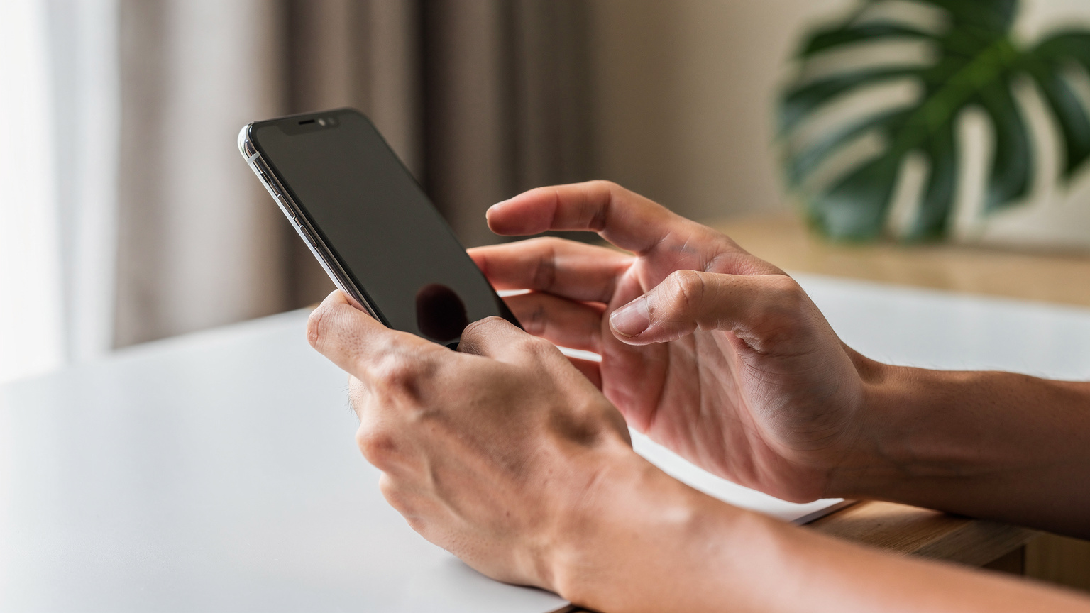 A close-up shot of a traveler's hands interacting with their smartphone, showing the ease of activating an eSIM.