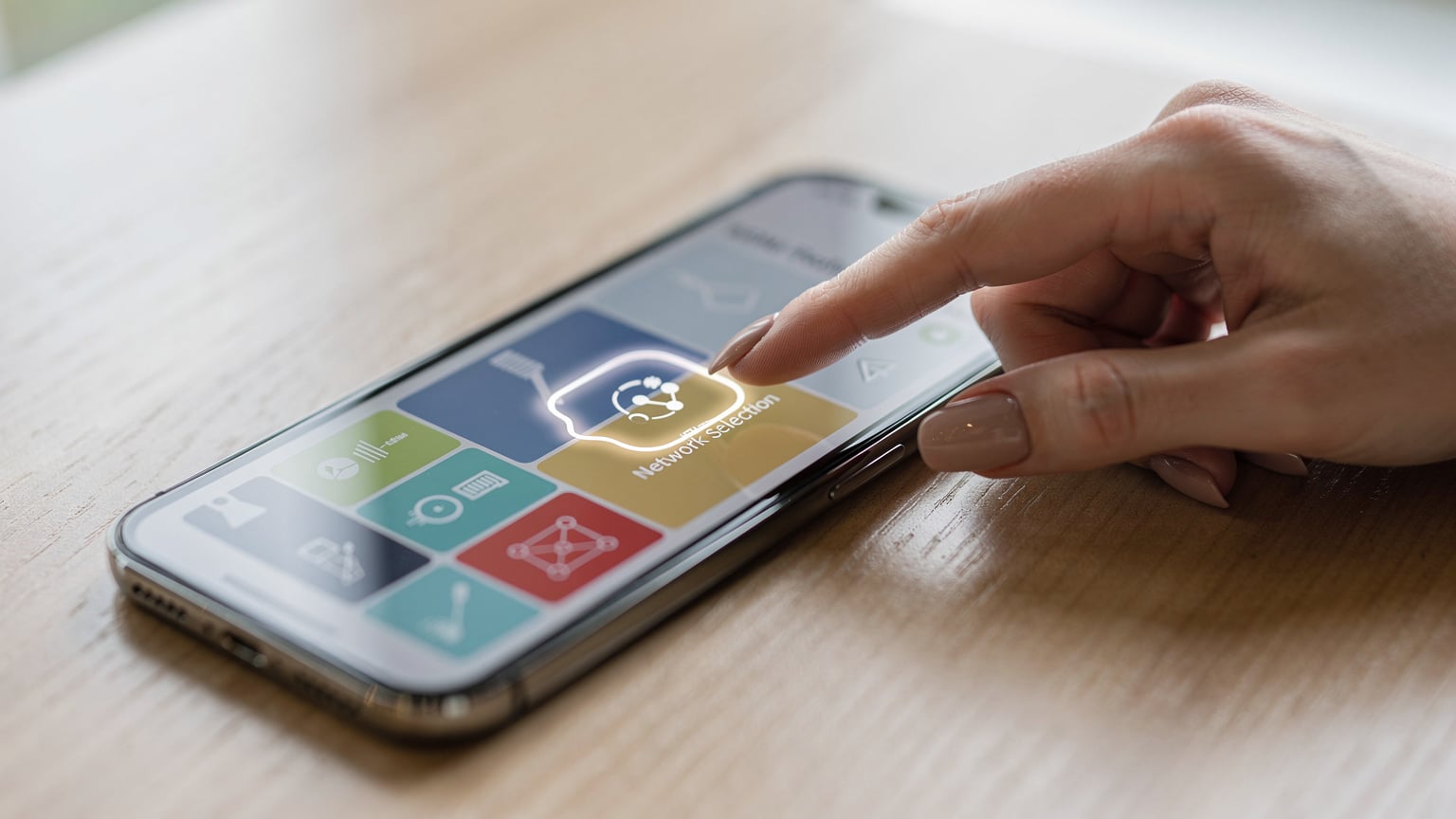 Gros plan sur un smartphone affichant les réglages réseau, avec la sélection d'un profil eSIM. Une main féminine pointe l'écran pour indiquer le choix du réseau.