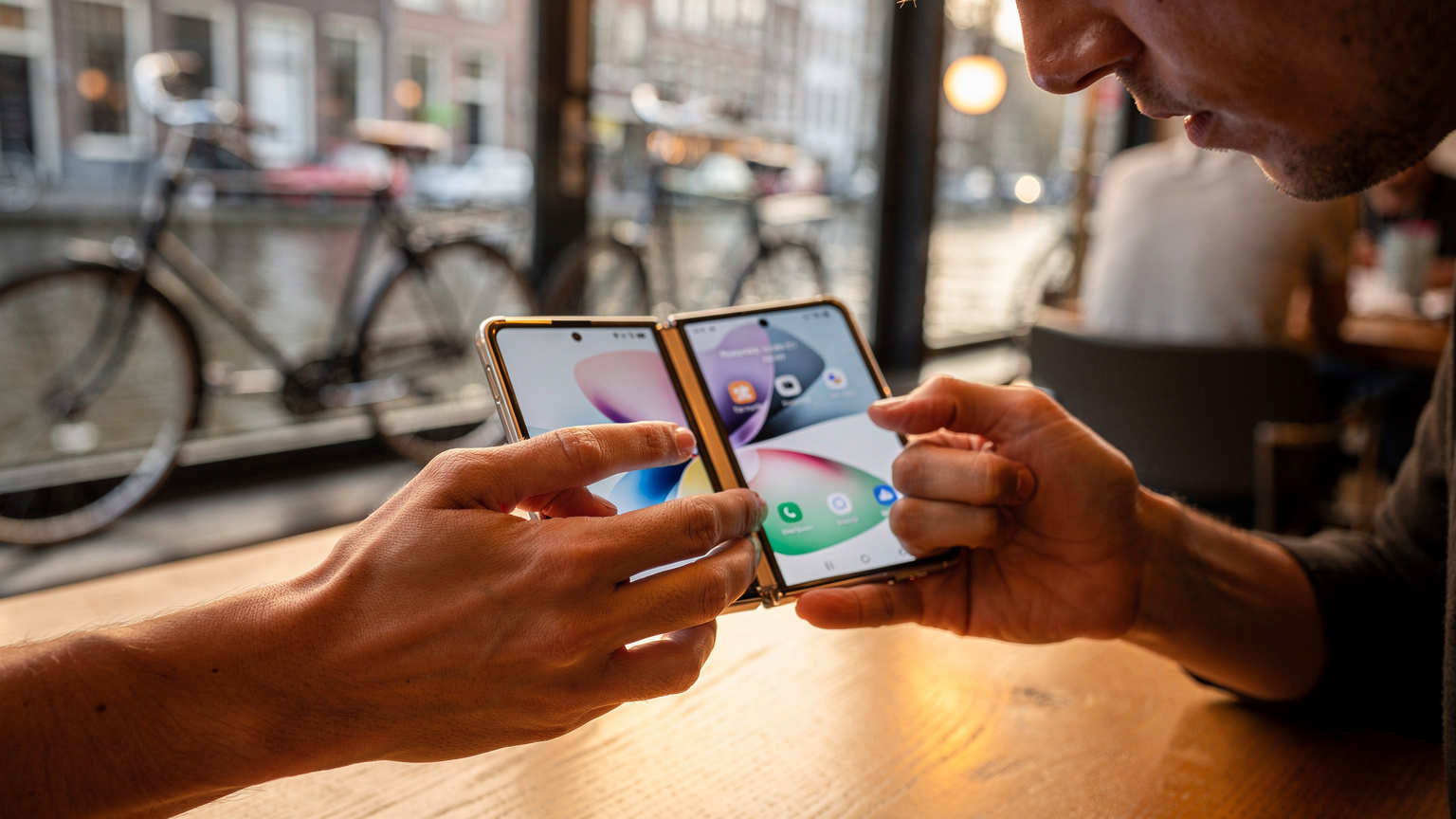 Een persoon die geconcentreerd naar de instellingen van een Samsung Galaxy Z Fold 7 kijkt, specifiek gericht op dataverbruik en eSIM-management.