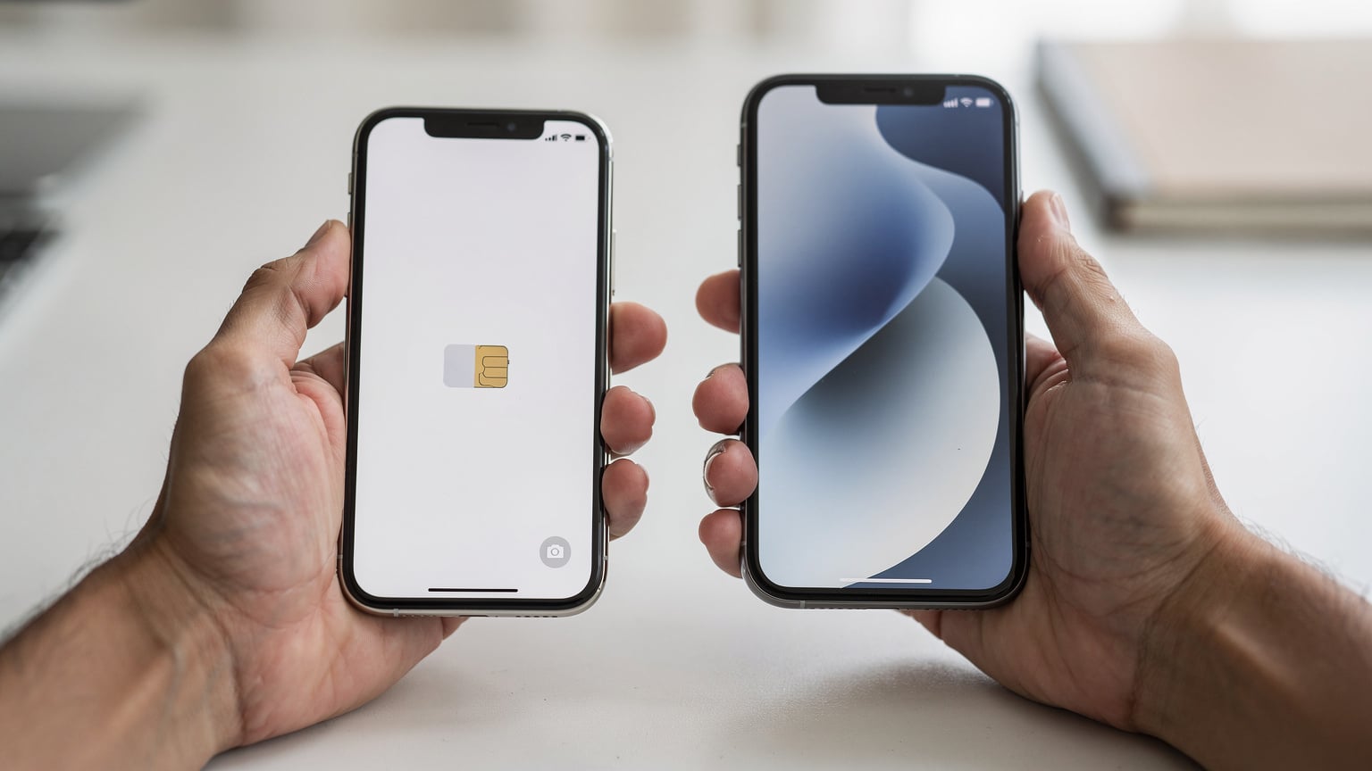 Tampilan dekat tangan seseorang yang memegang iPhone lama dan iPhone baru secara berdampingan, dengan fokus pada layar iPhone lama yang menampilkan opsi "Transfer eSIM".