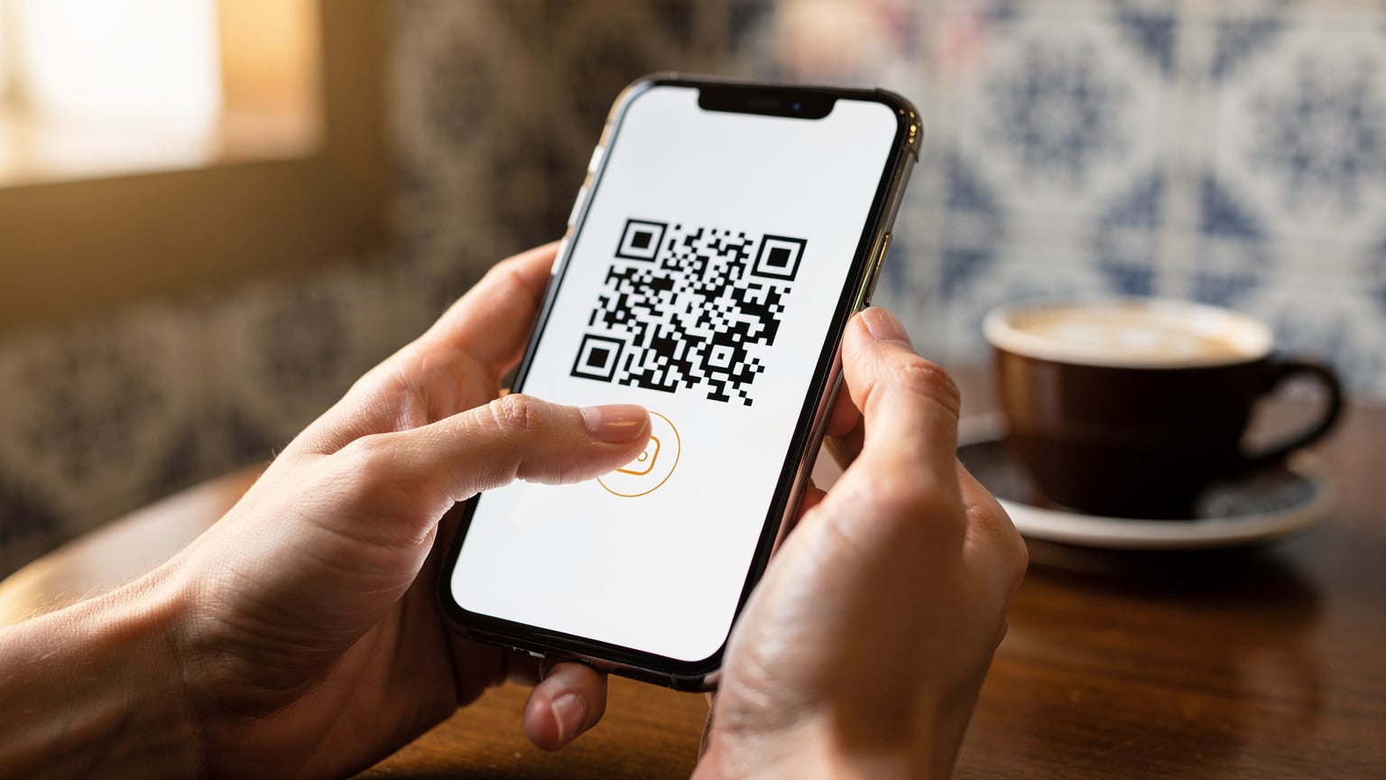 Manos de un viajero sosteniendo un smartphone, mostrando el proceso de escaneo de un código QR para activar una eSIM, con el fondo desenfocado de un café en el centro de Oporto.