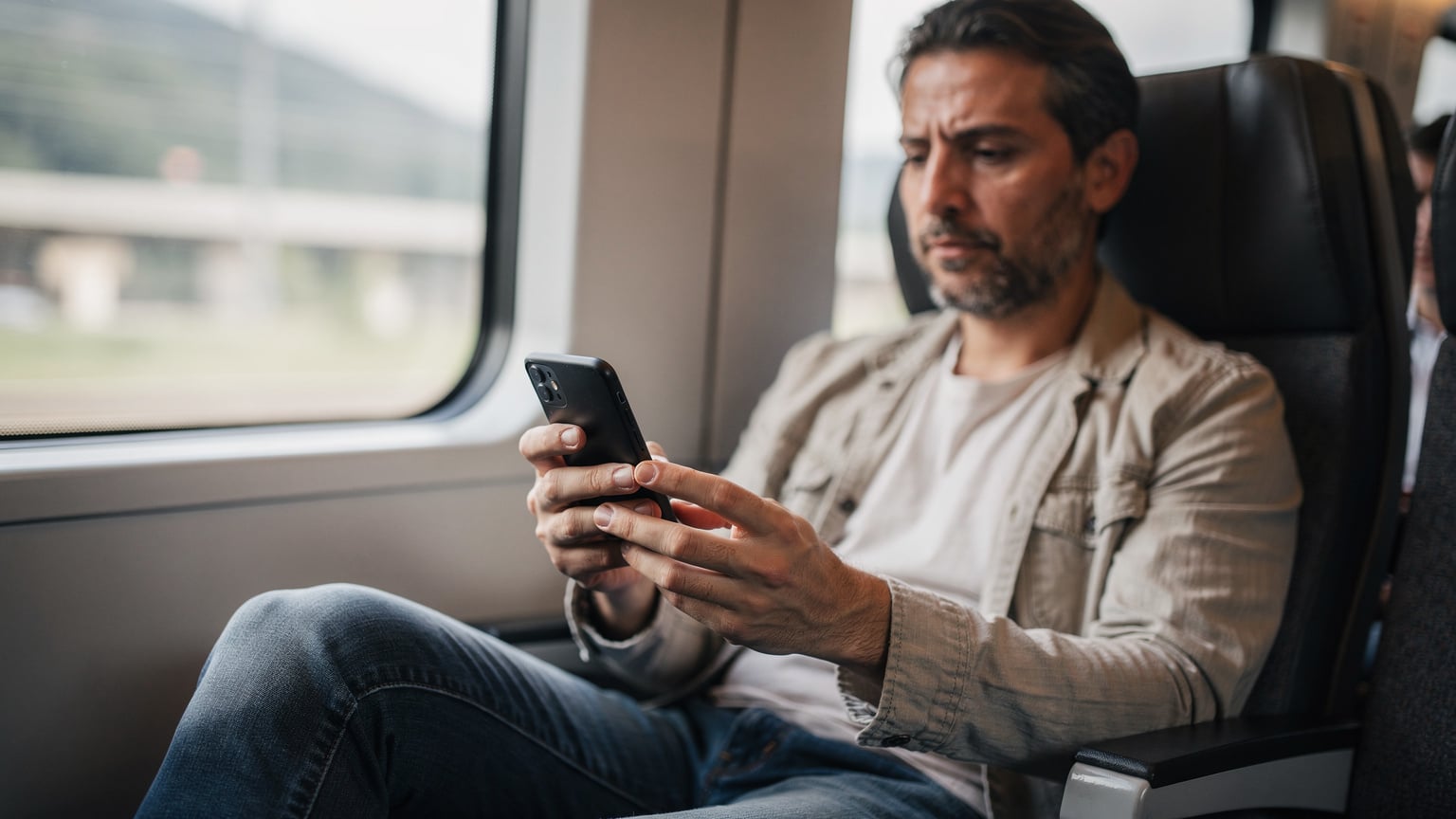 Avrupa'da bir trende oturan Türk bir ebeveyn, uçağın inişinden hemen sonra telefonunu yeniden başlatmak için kapatıyor.