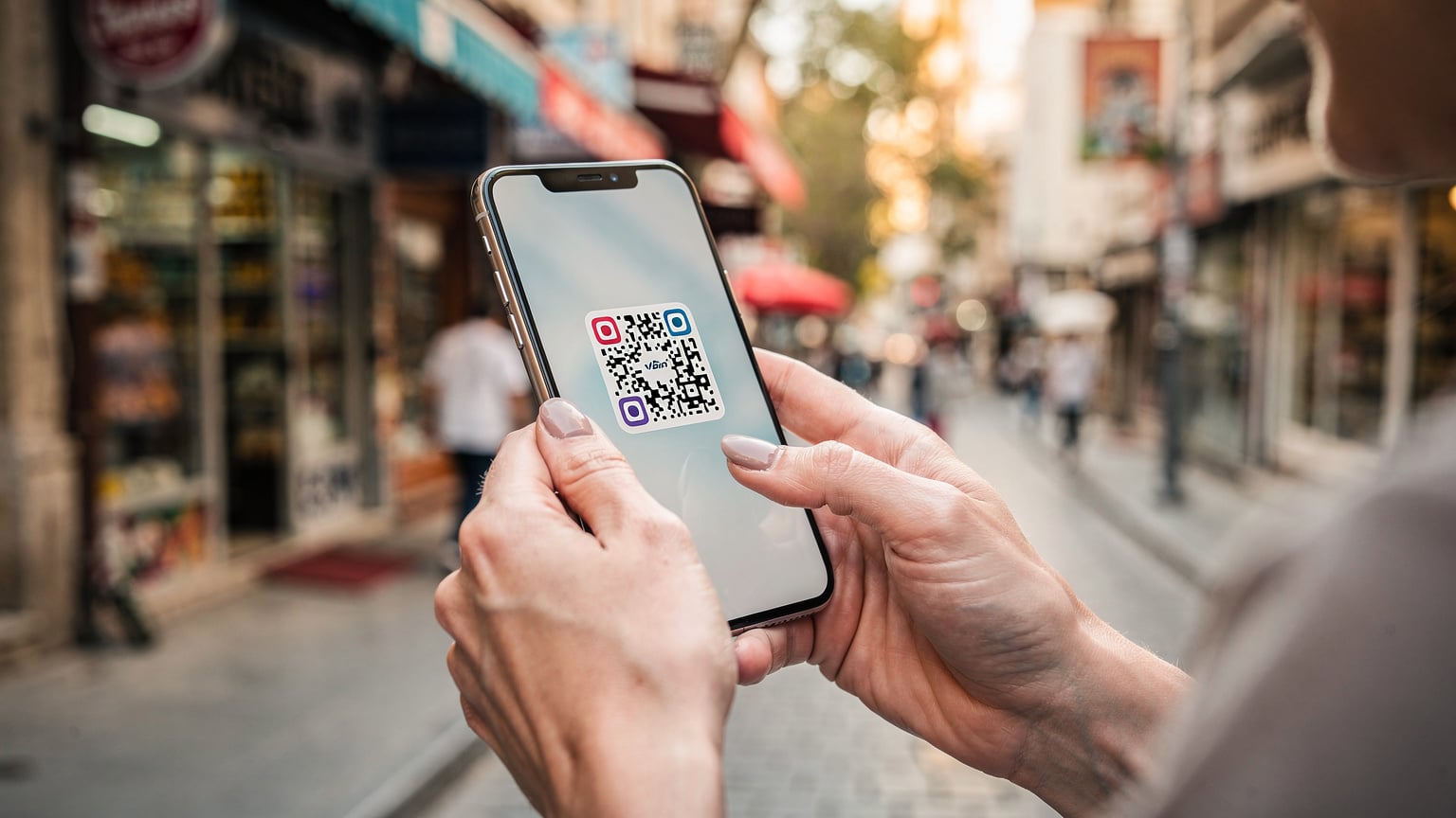 Μια γυναίκα κρατά το smartphone της, σκανάροντας έναν QR κωδικό για την ενεργοποίηση της eSIM της, με φόντο έναν πολυσύχναστο δρόμο στην Κωνσταντινούπολη.