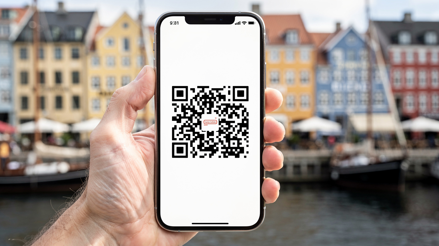 En hand håller en smartphone som visar en QR-kod för eSIM-installation, med en suddig bakgrund av Köpenhamns färgglada hus vid Nyhavn.