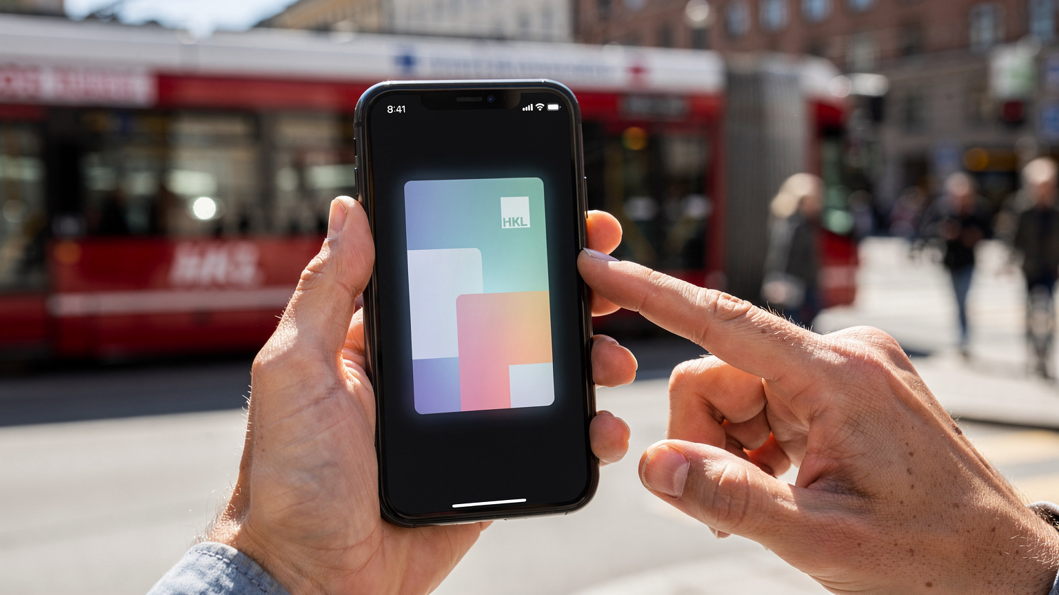 Close-up van handen die een Finse reistelefoon vasthouden met een digitale ticket voor het openbaar vervoer in Helsinki, terwijl de iconische rode trams op de achtergrond voorbijrijden.