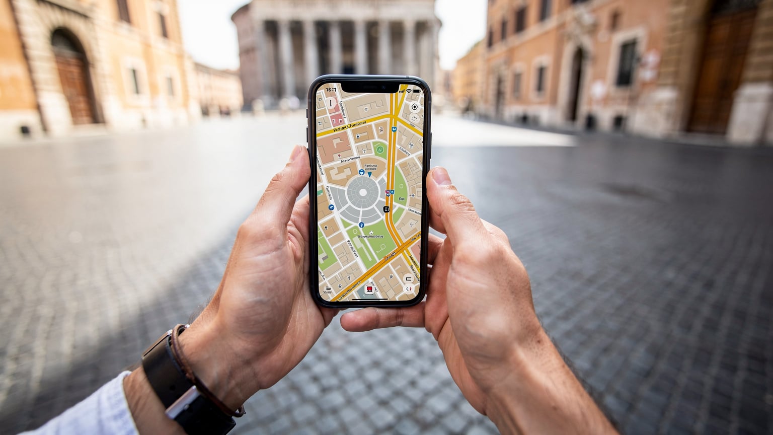 A traveler's hands holding a smartphone displaying Google Maps, showing a detailed map of the Pantheon area in Rome, Italy, with historic buildings in the background.