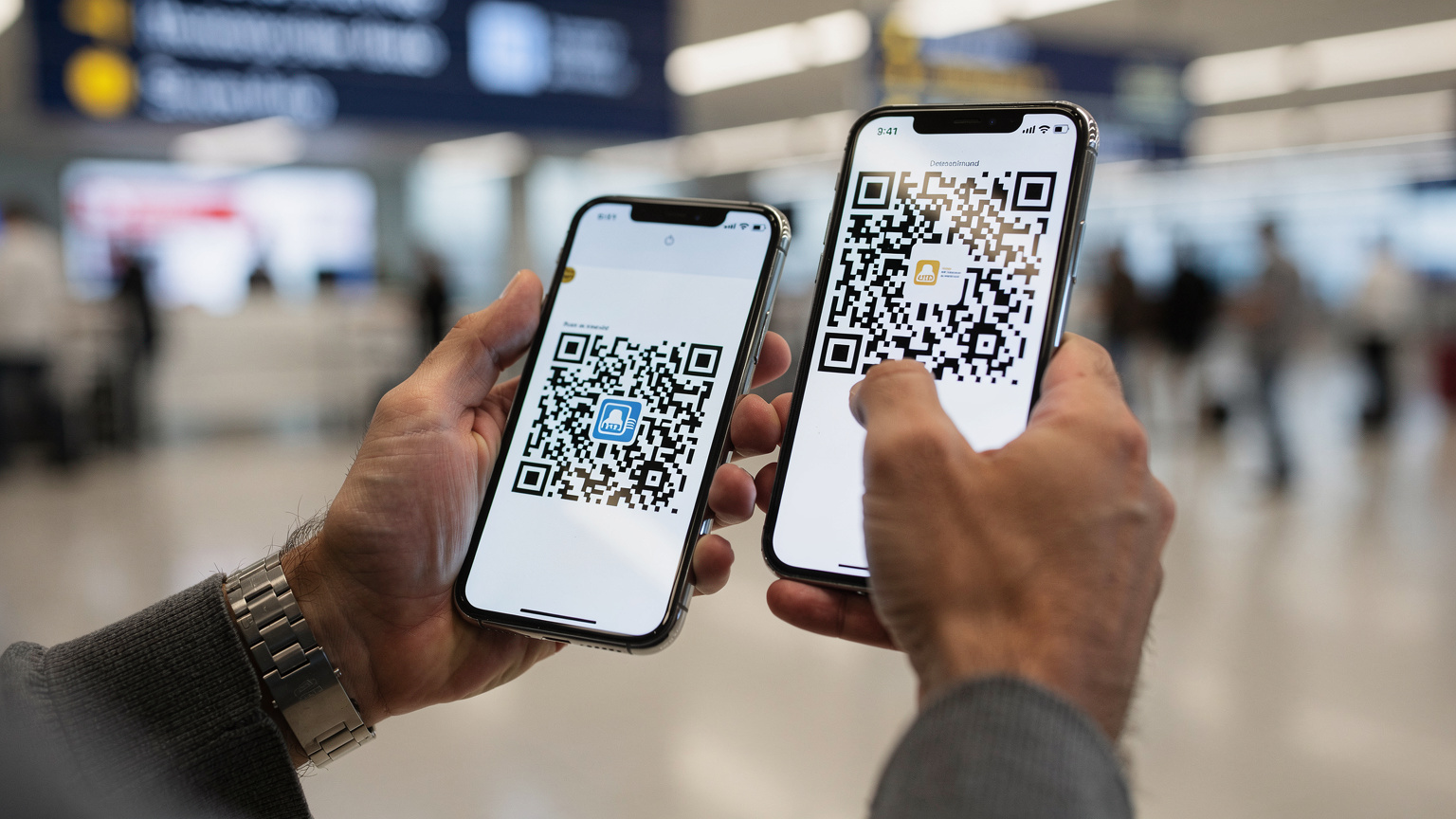 Un primer plano de la mano de un viajero escaneando un código QR en la pantalla de otro teléfono para activar una eSIM, en el área de llegadas del Aeropuerto Internacional de Carrasco en Montevideo. La luz es brillante y artificial.