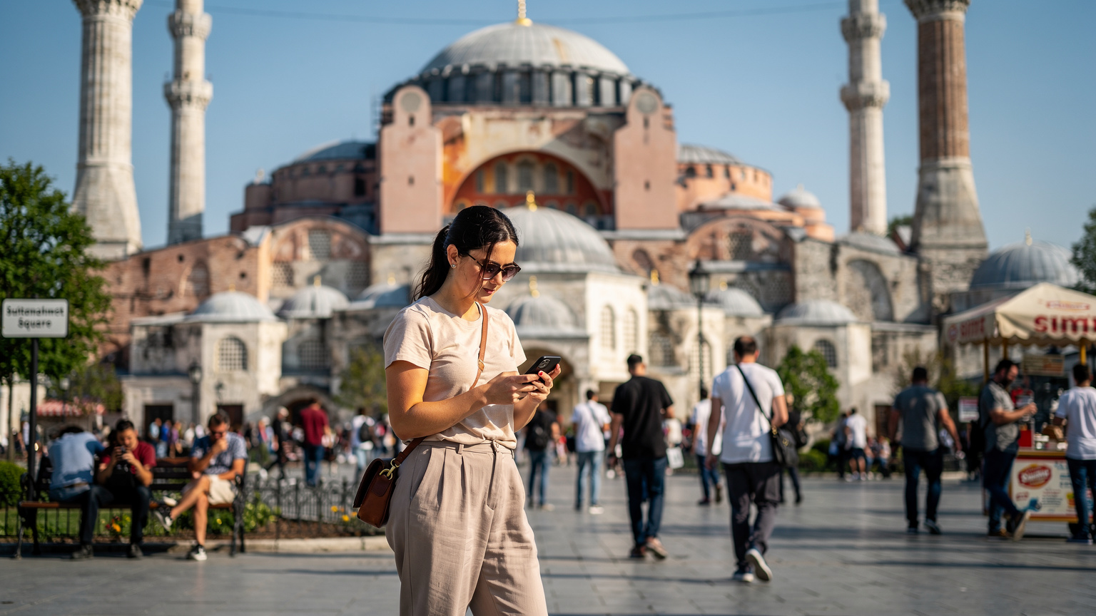 O femeie vizitează Hagia Sofia, verificându-și telefonul pentru a găsi traseul, în timp ce se bucură de conectivitate neîntreruptă cu un eSIM.