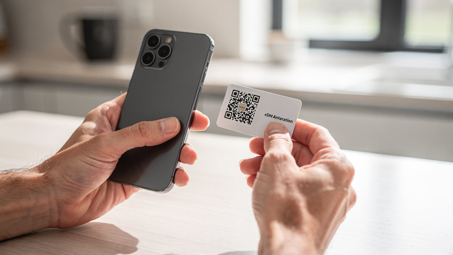 Un primo piano di una mano che scansiona un codice QR su un pacchetto eSIM con un altro smartphone, in un ambiente di cucina casalinga ben illuminata.