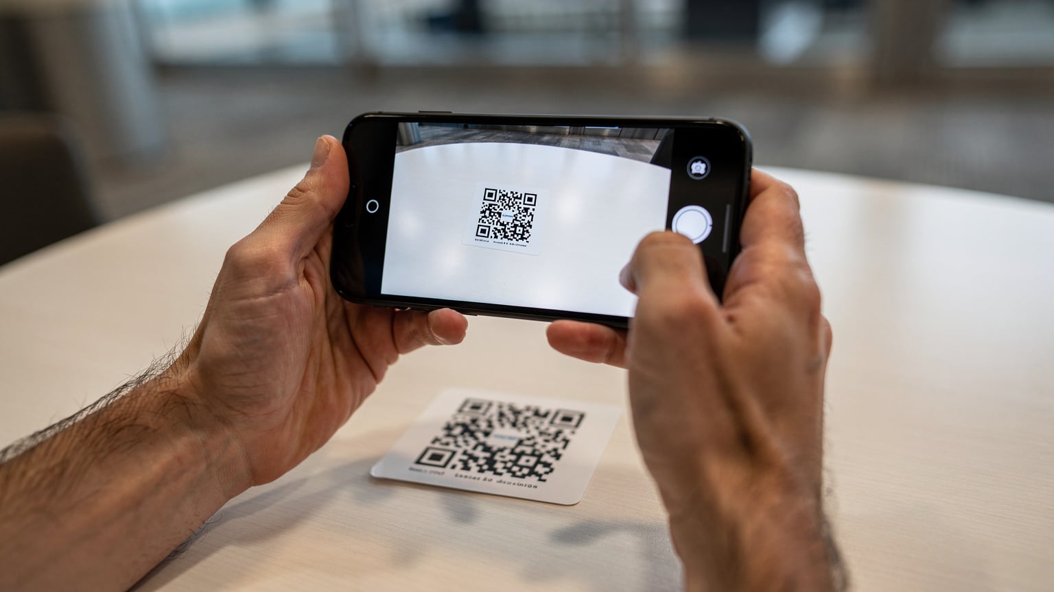Manos escaneando un código QR para activar una eSIM en un smartphone.
