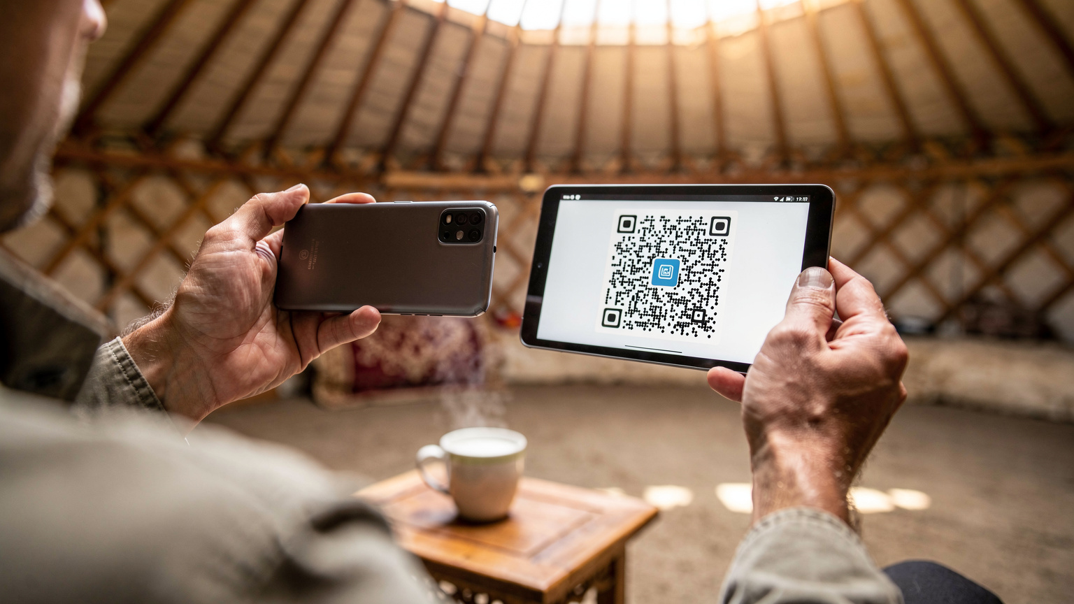 몽골 전통 게르에서 한 여행자가 휴대폰으로 이심 설치를 위해 QR 코드를 스캔하고 있다.
