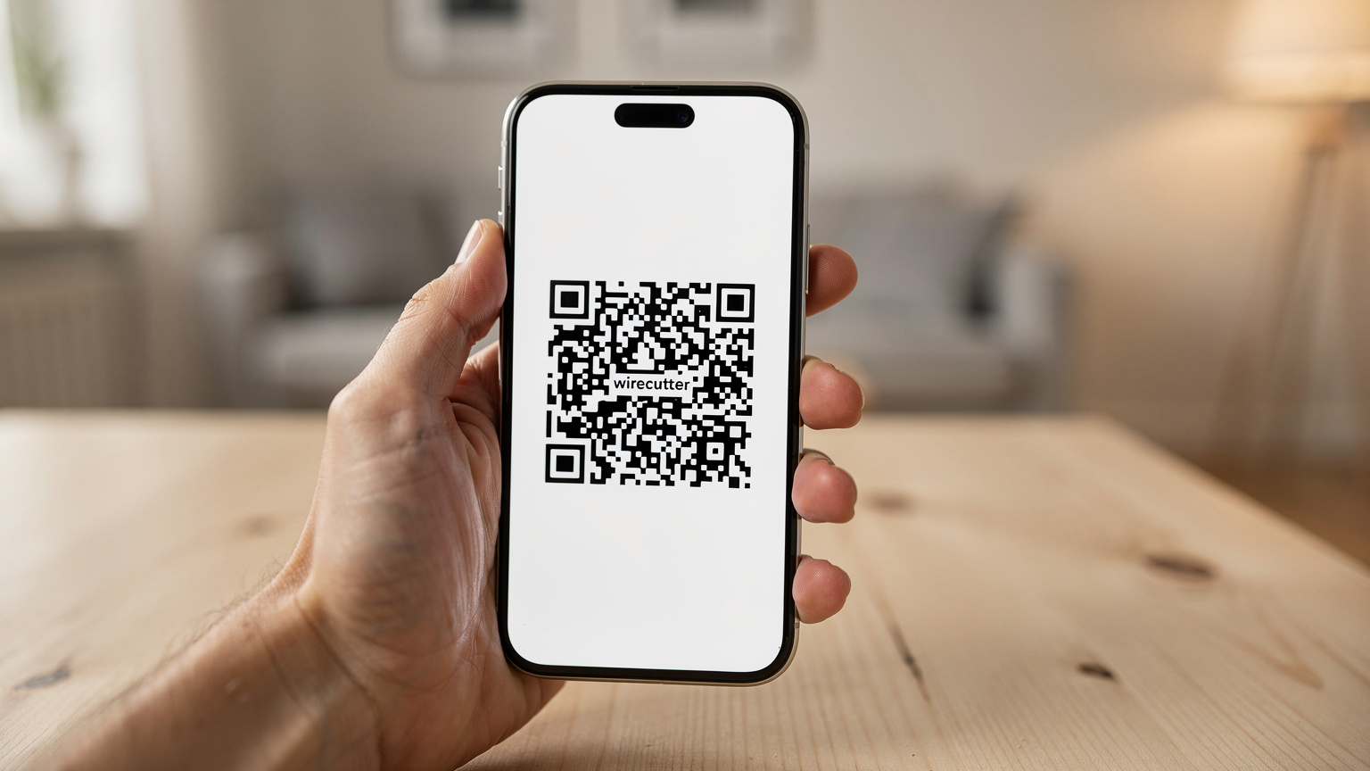 Et nærbilde av en hånd som holder en smarttelefon, med en QR-kode for eSIM-aktivering tydelig synlig på skjermen, i en hyggelig nordisk hjemmeomgivelse.